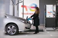 Woman charging her vehicle at the electric station