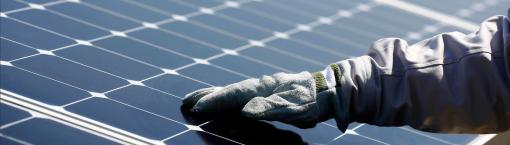 Main gantée sur un panneau solaire de la centrale photovoltaïque mise en service par ISE, Total et SunPower. Nanao, Japon.