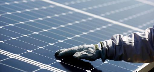 Main gantée sur un panneau solaire de la centrale photovoltaïque mise en service par ISE, Total et SunPower. Nanao, Japon.
